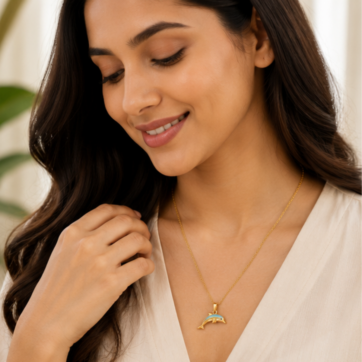 Gold-finish dolphin necklace featuring blue enamel and tiny stone detailing by Maelle