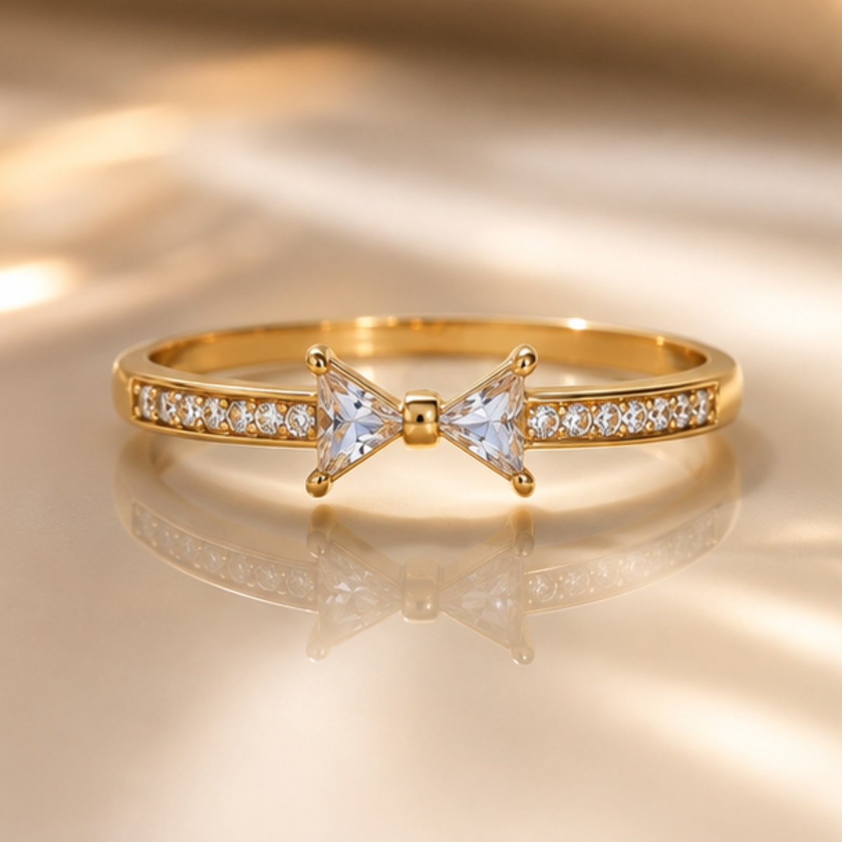 Delicate gold tone bangle featuring a sparkling bow-shaped crystal design by Maelle