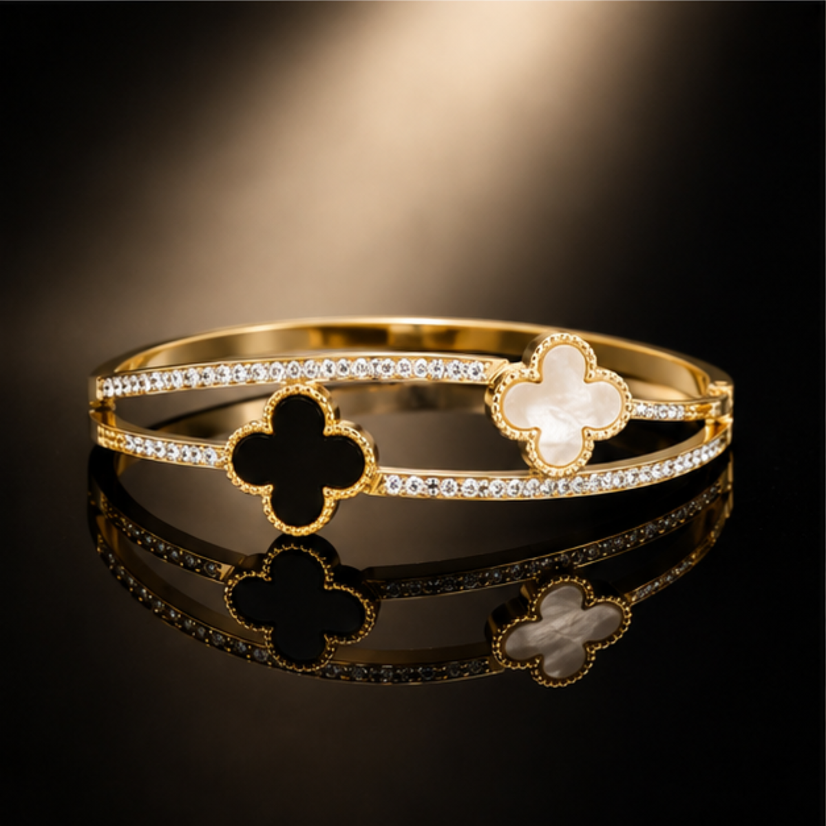 Delicate gold tone clover bangle featuring refined crystal accents and a polished finish by Maelle