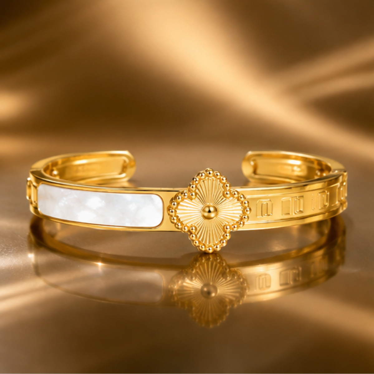 Delicate gold tone cuff bracelet with a refined floral design and open silhouette by Maelle