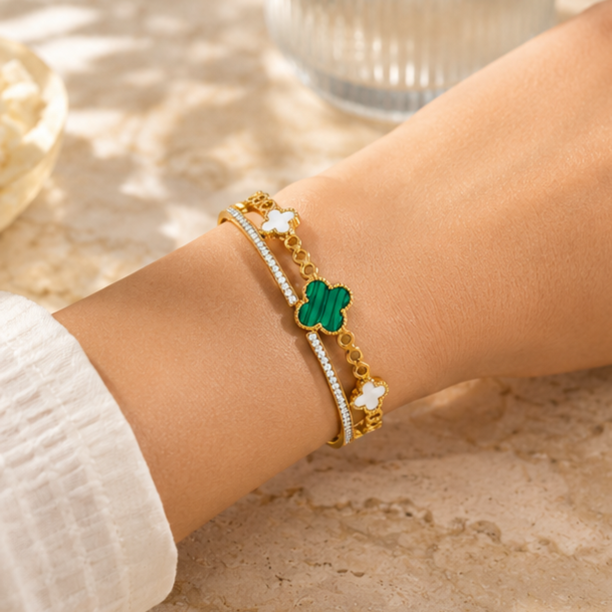 Delicate gold tone charm bracelet featuring a green clover pendant by Maelle