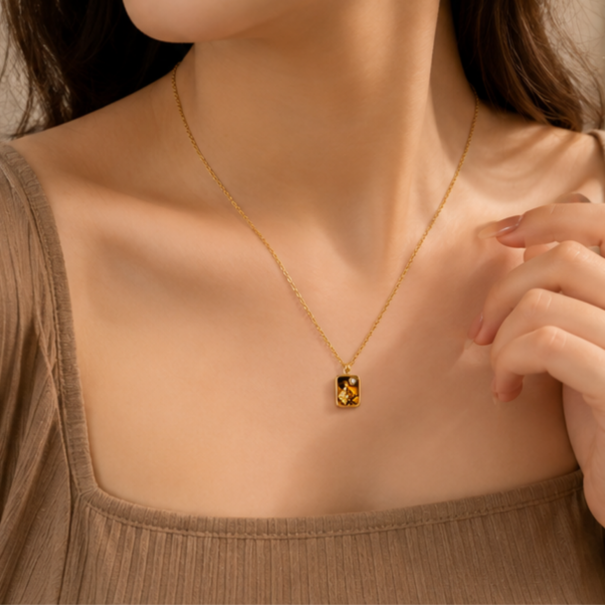 Delicate gold tone necklace featuring a minimalist square pendant by Maelle