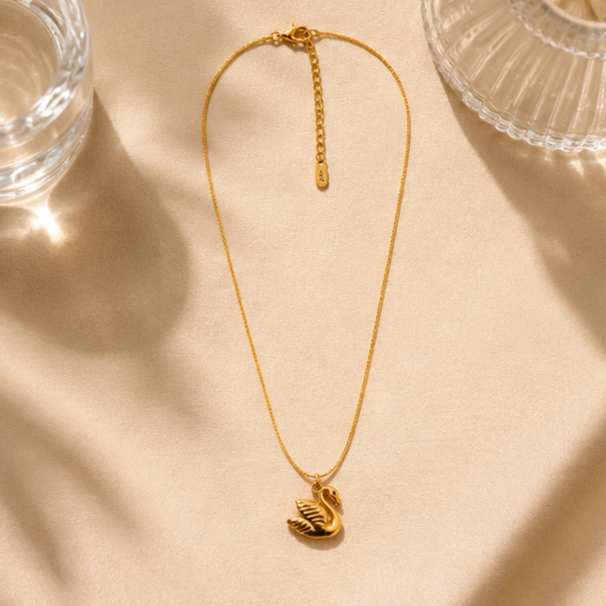 Delicate gold tone necklace featuring an elegant swirl pendant by Maelle