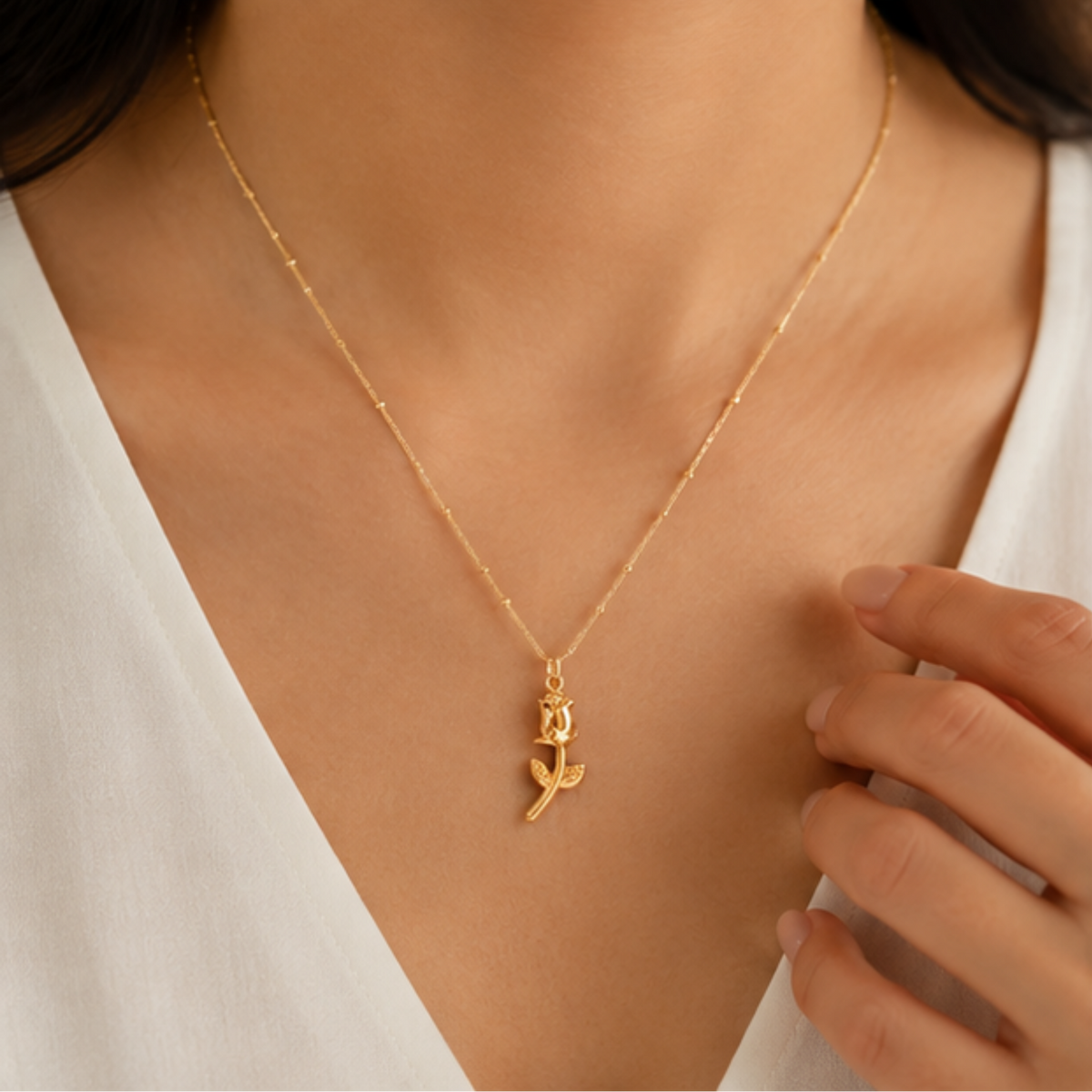 Elegant gold botanical pendant necklace featuring a small floral design and delicate chain | Maelle