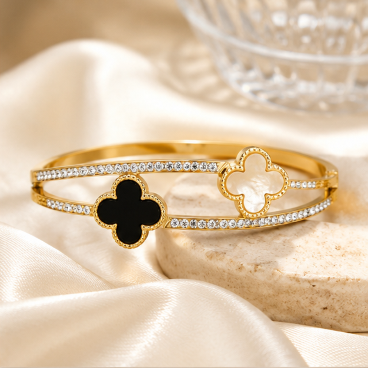 Elegant gold tone bangle with a clover charm and sparkling crystal accents for women by Maelle
