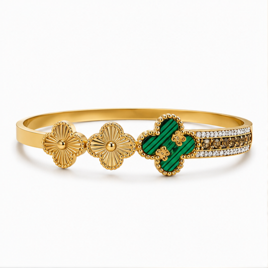 Maelle gold tone floral bangle featuring green clover accents and sparkling crystal details