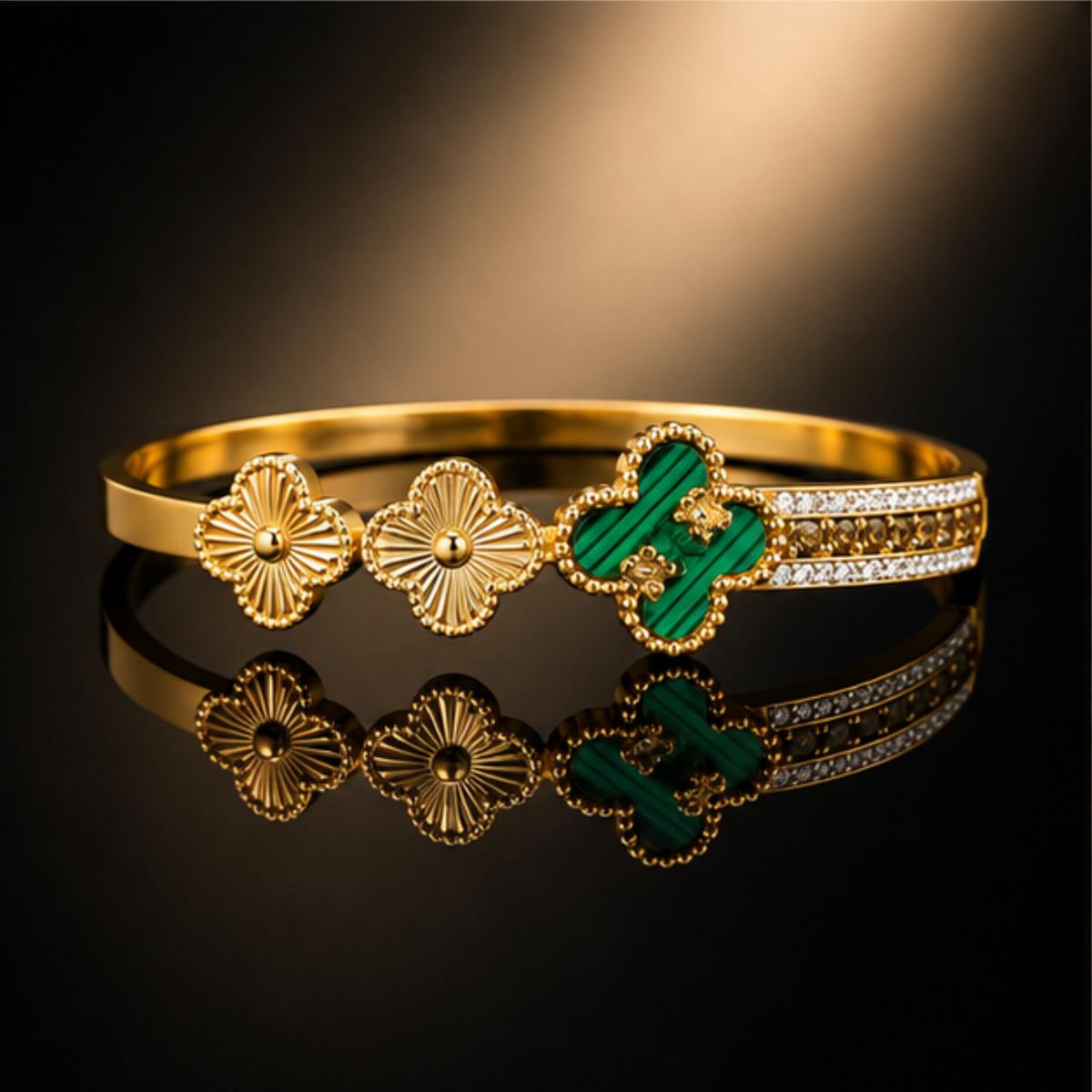 Gold tone bangle bracelet featuring green clover motifs, floral accents, and sparkling crystal details by Maelle