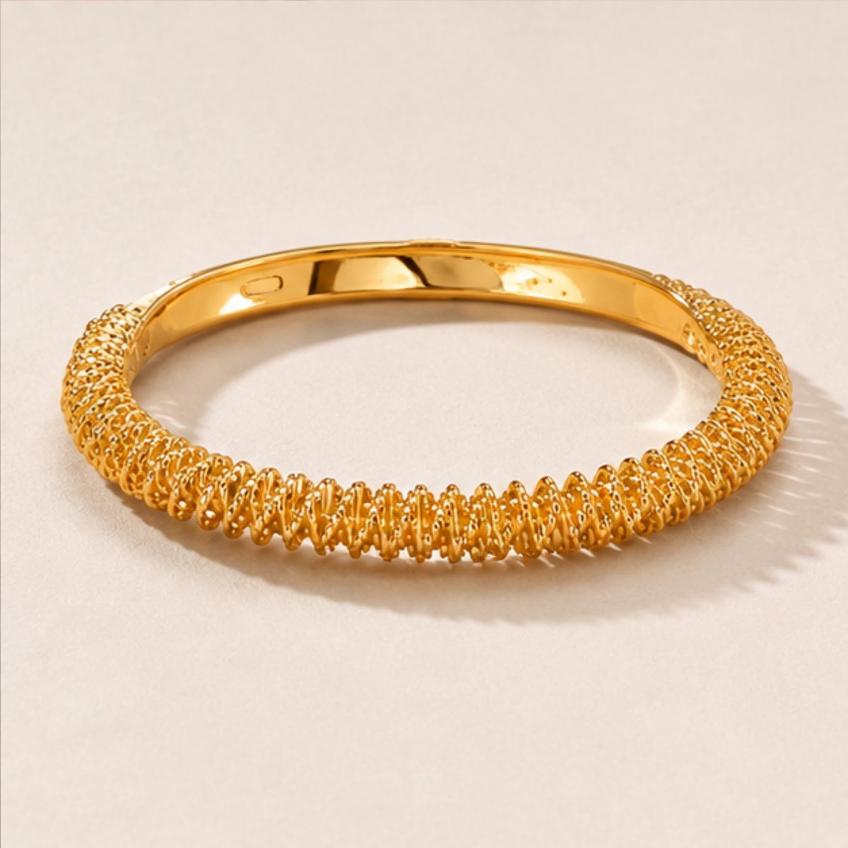 Gold tone textured bangle bracelet designed for everyday elegance and sophisticated styling by Maelle